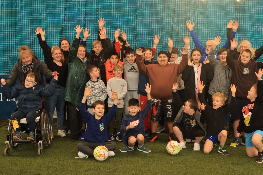 Lehrerinnen und Betreuerinnen von der Adolf-Rebl-Schule sowie Robert Schröder (Fünfter von rechts), Vorstands-Mitglied des Jugendfußball-Fördervereins, freuen sich über die Begeisterung der jungen Kicker. Foto: Ralph Steffen