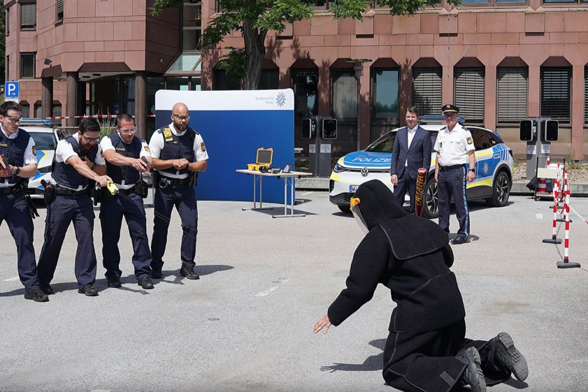 Innenstaatssekretär Sandro Kirchner beim Pressetermin zum Startschuss für die Pilotphase zur Ausweitung des Einsatzes von Distanz-Elektroimpuls-Geräten bei der Polizeiinspektion in Schweinfurt. Foto: Polizeipräsidium Unterfranken